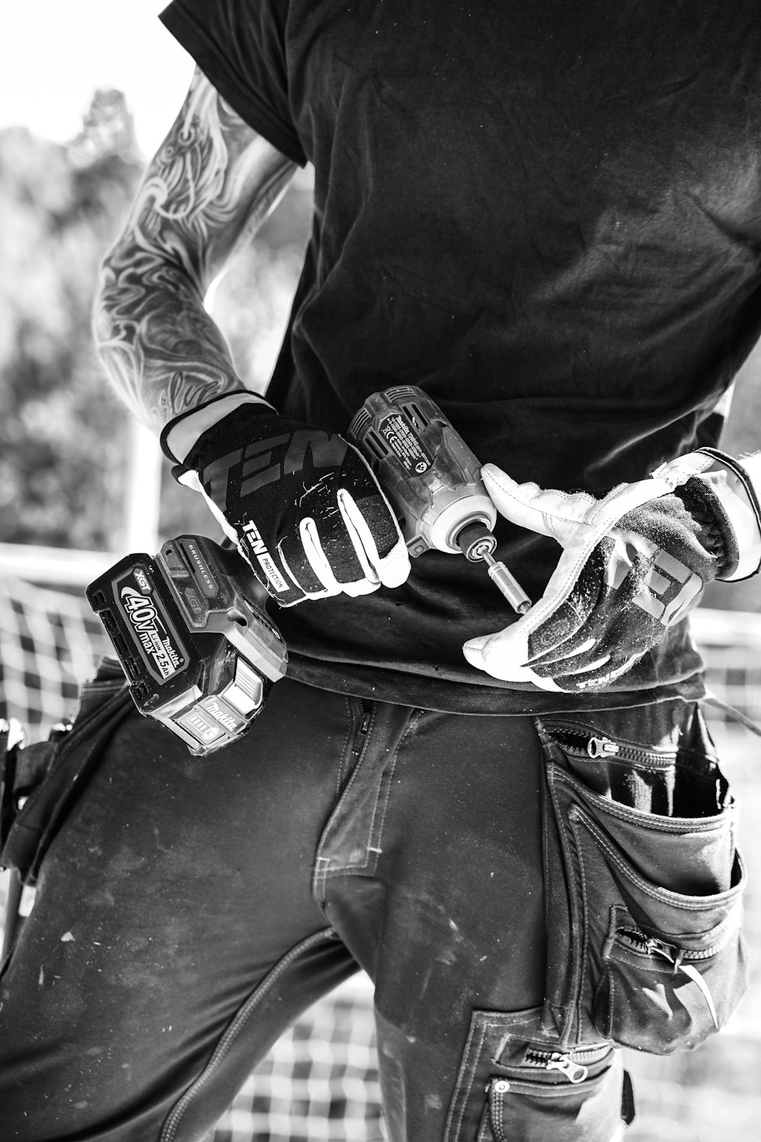 Carpenter with work gloves holding a drill machine.